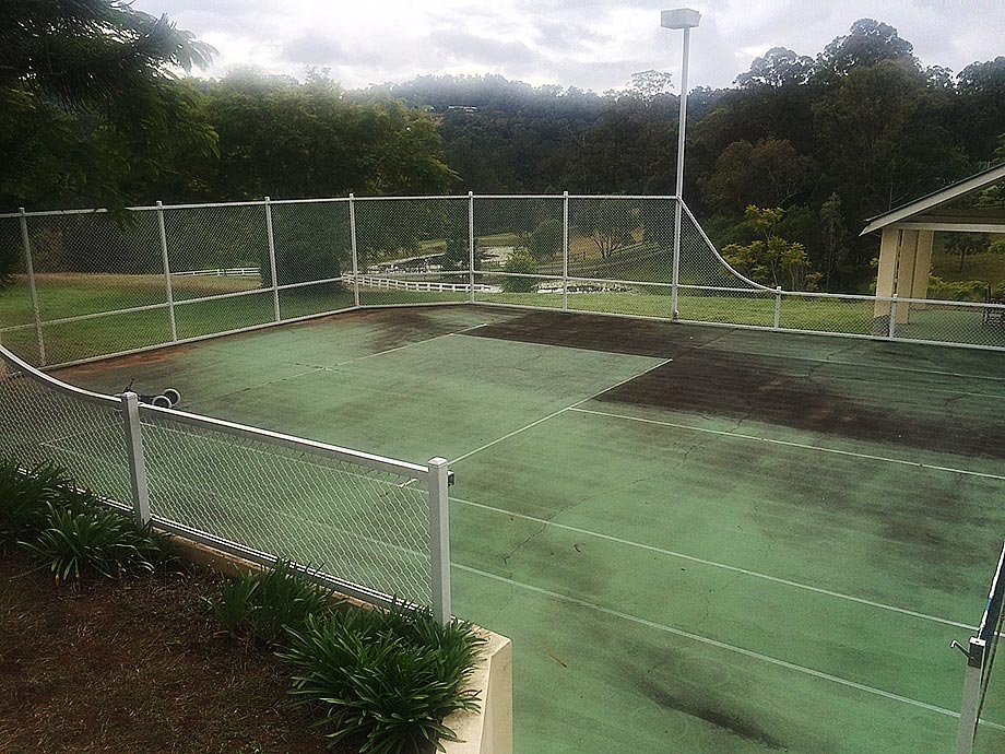 Dirty tennis court before professional pressure cleaning