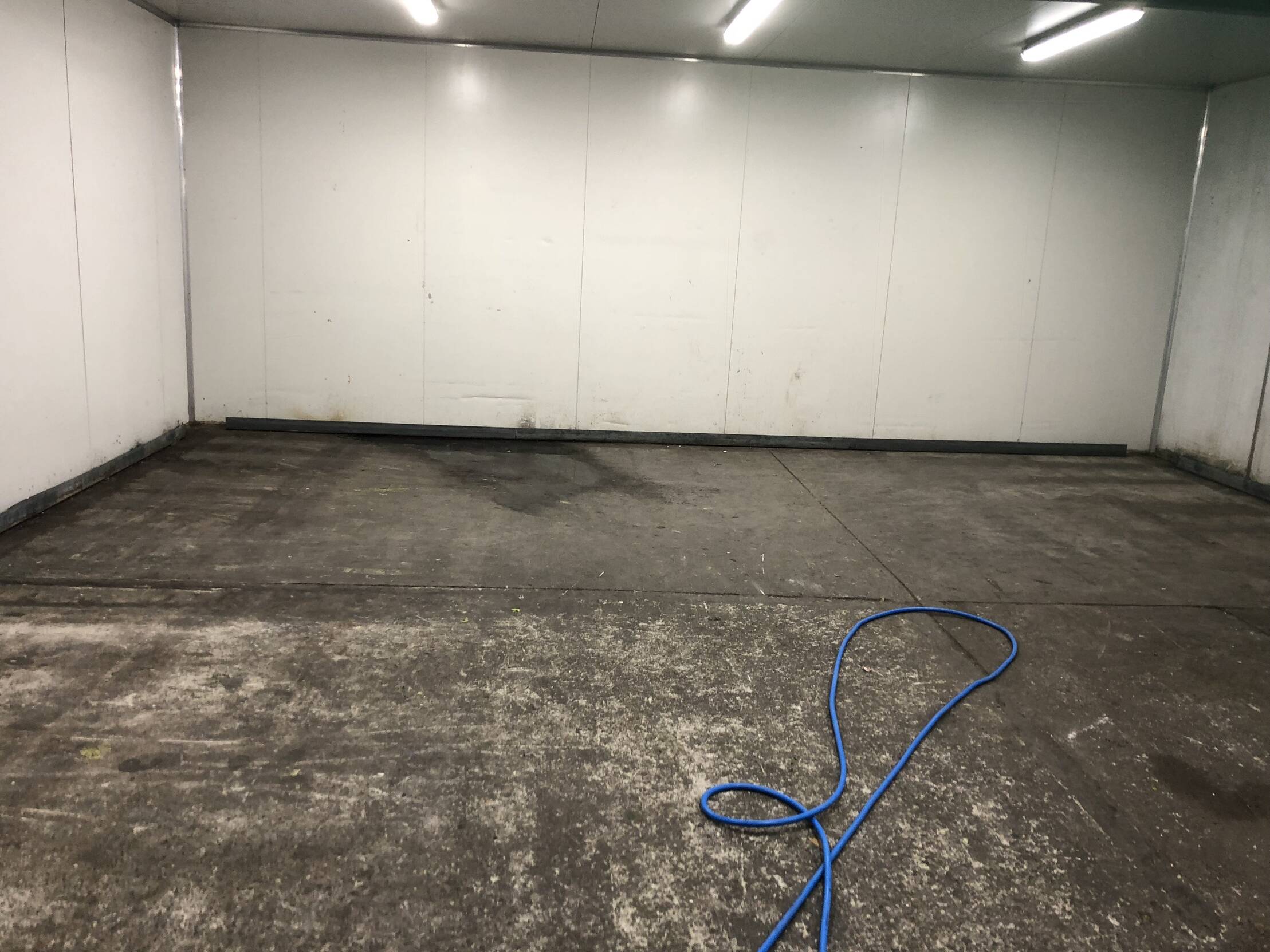 Concrete floor with a blue hose pipe