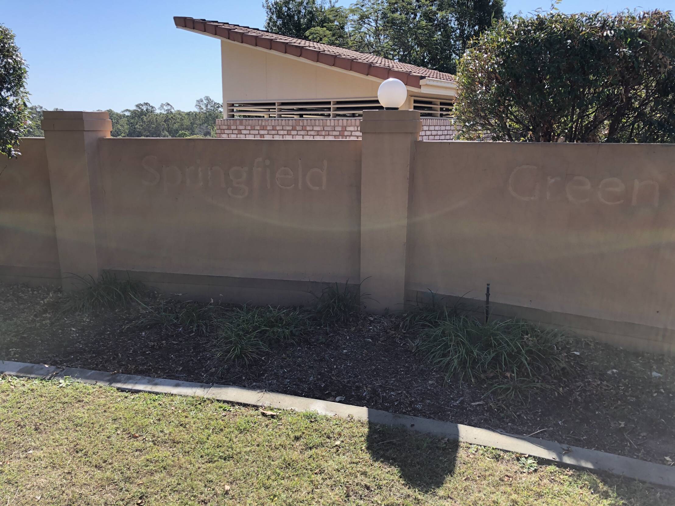 Wall with Springfield Green written on it and a property behind