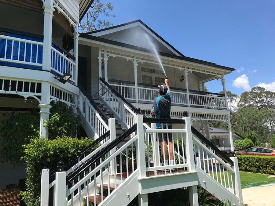 Man washing the outside of a residential home in Brisbane