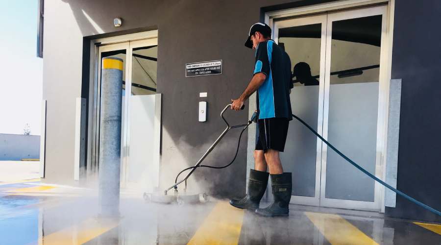 Man pressure clean the ground outside of a Brisbane business