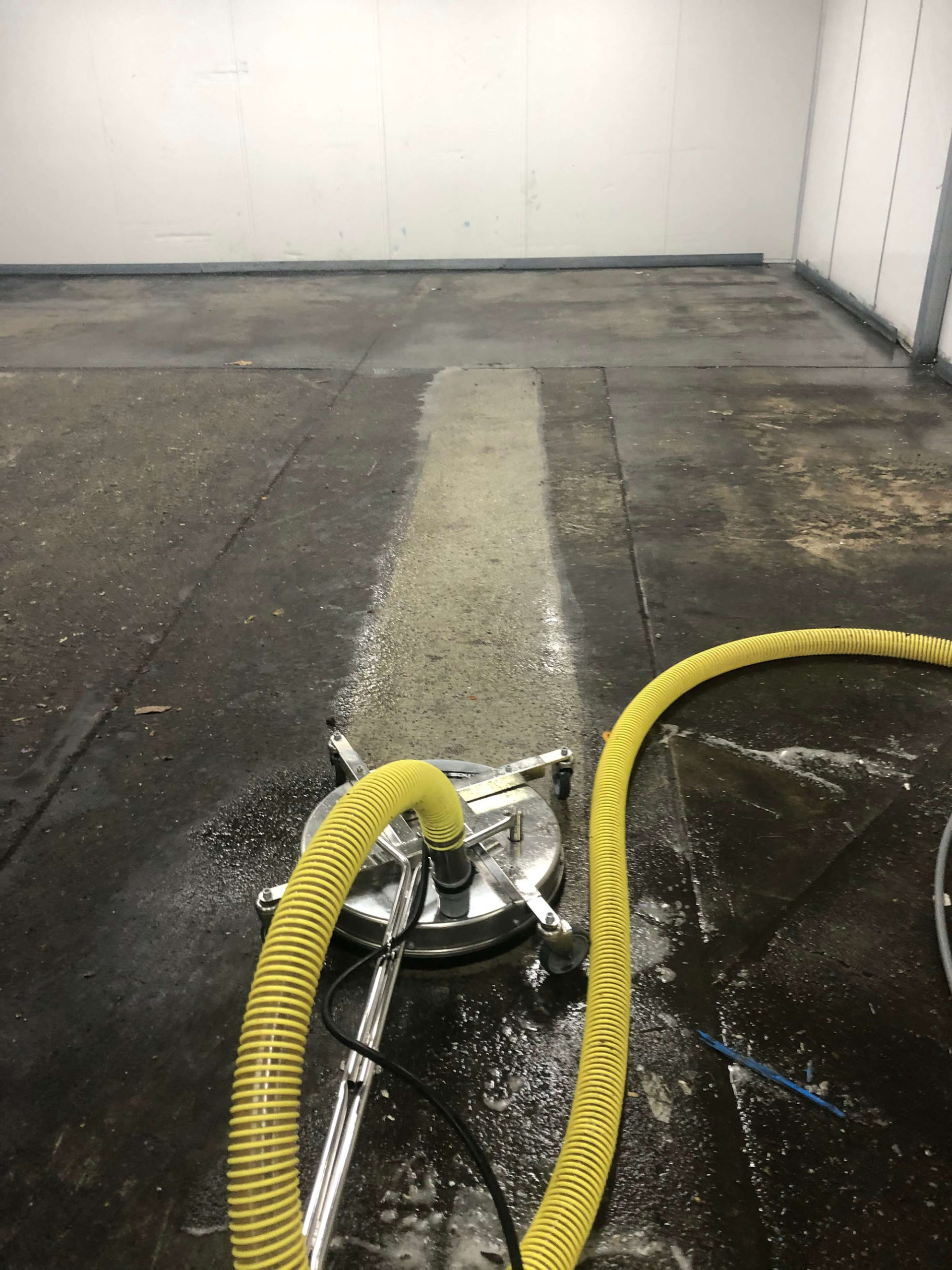 Vacuum water recover machine in use whilst professionally cleaning concrete