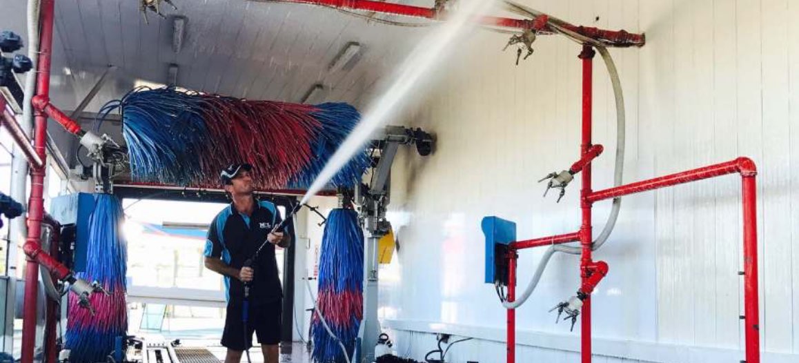 Man pressure washing a carwash