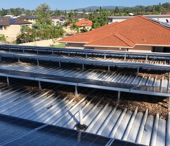 View of a residential roof with solar panels requiring cleaning