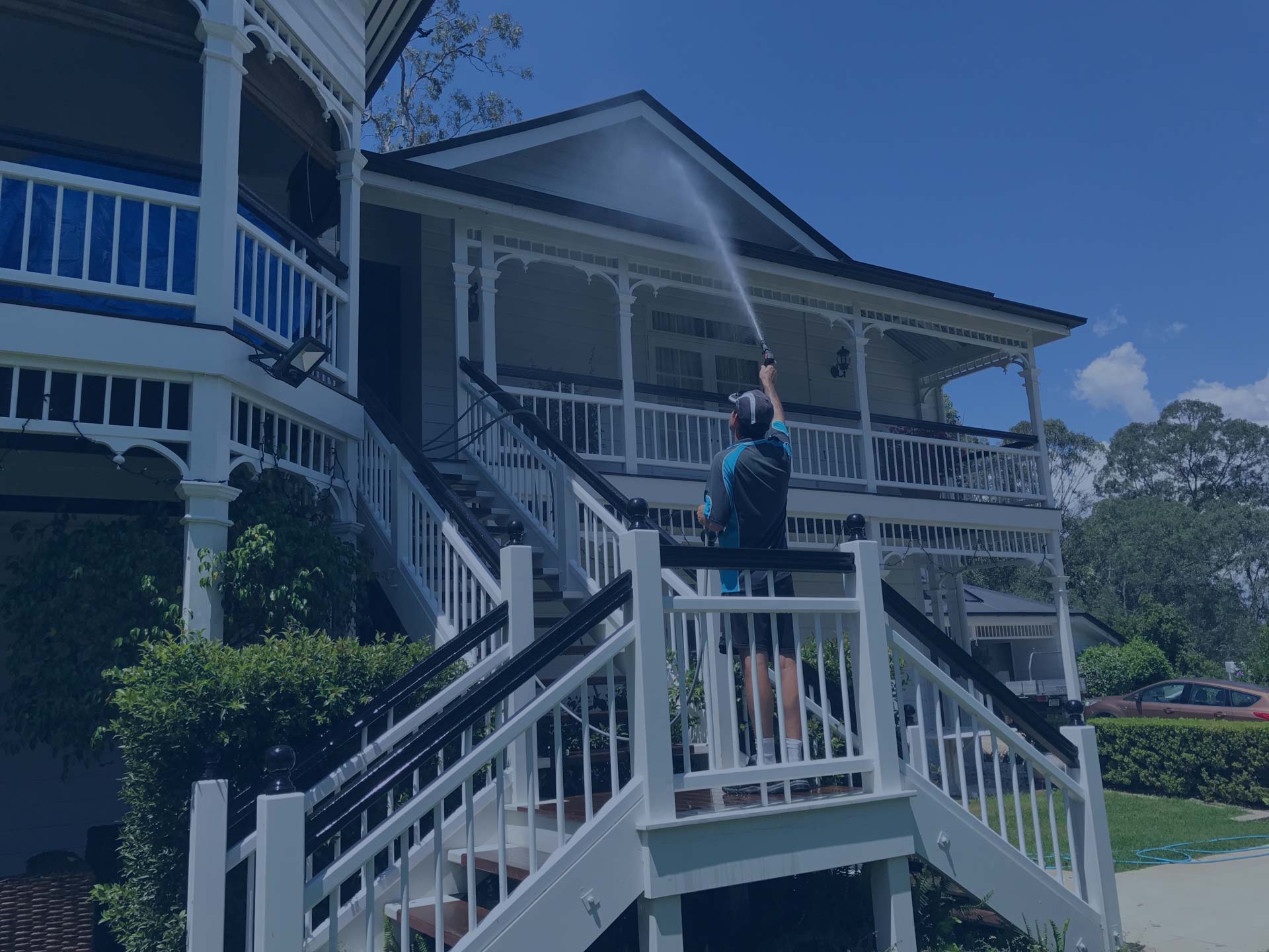 Man pressure washing a Brisbane home